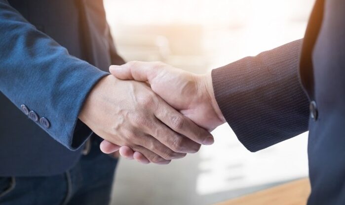 Two business professionals shaking hands after a successful young durian import deal